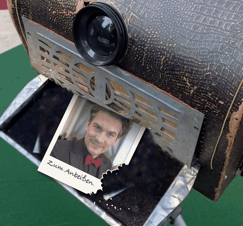 Der Esspapier-Print wird vorne aus der historischen Plattenkamera gedruckt, entwickelt sich zum Porträt und wird angeknabbert